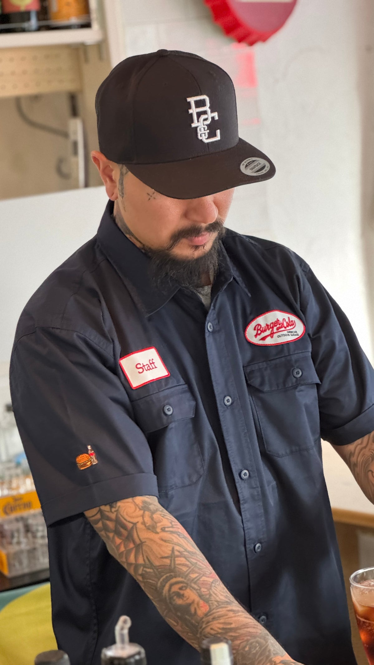 BURGER&COLA B&C BASEBALL CAP（ベースボールキャップ）黒キャップ着用イメージ、店内でスタッフシャツと合わせて