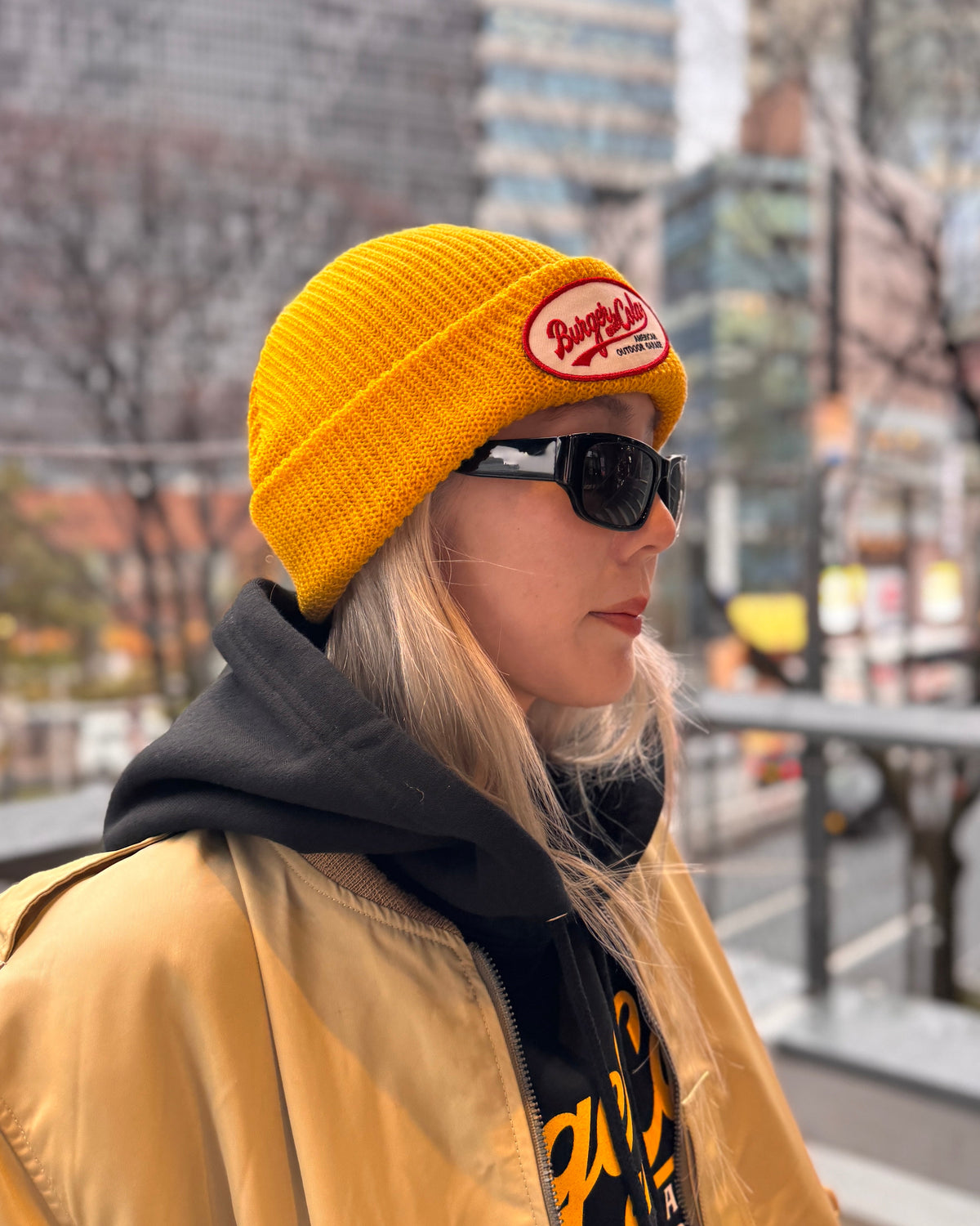 BURGER&COLA B&C OVAL Patch Beanie（ビーニー）マスタード色のワッペンのアップ（横向き、着用）