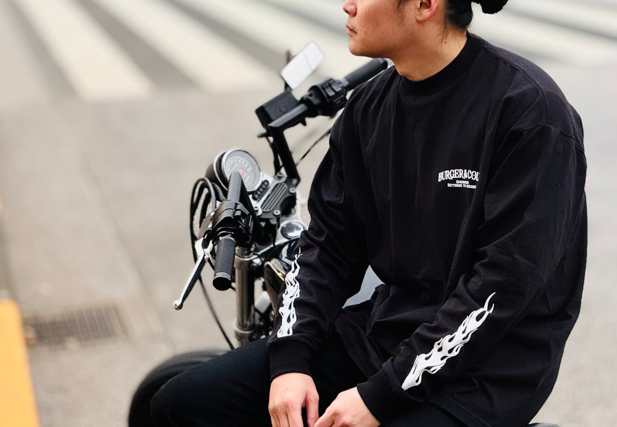 BURGER&COLA FIRE L/S Tee（長袖Tシャツ）着用イメージ、黒Tシャツ横向き（自転車）